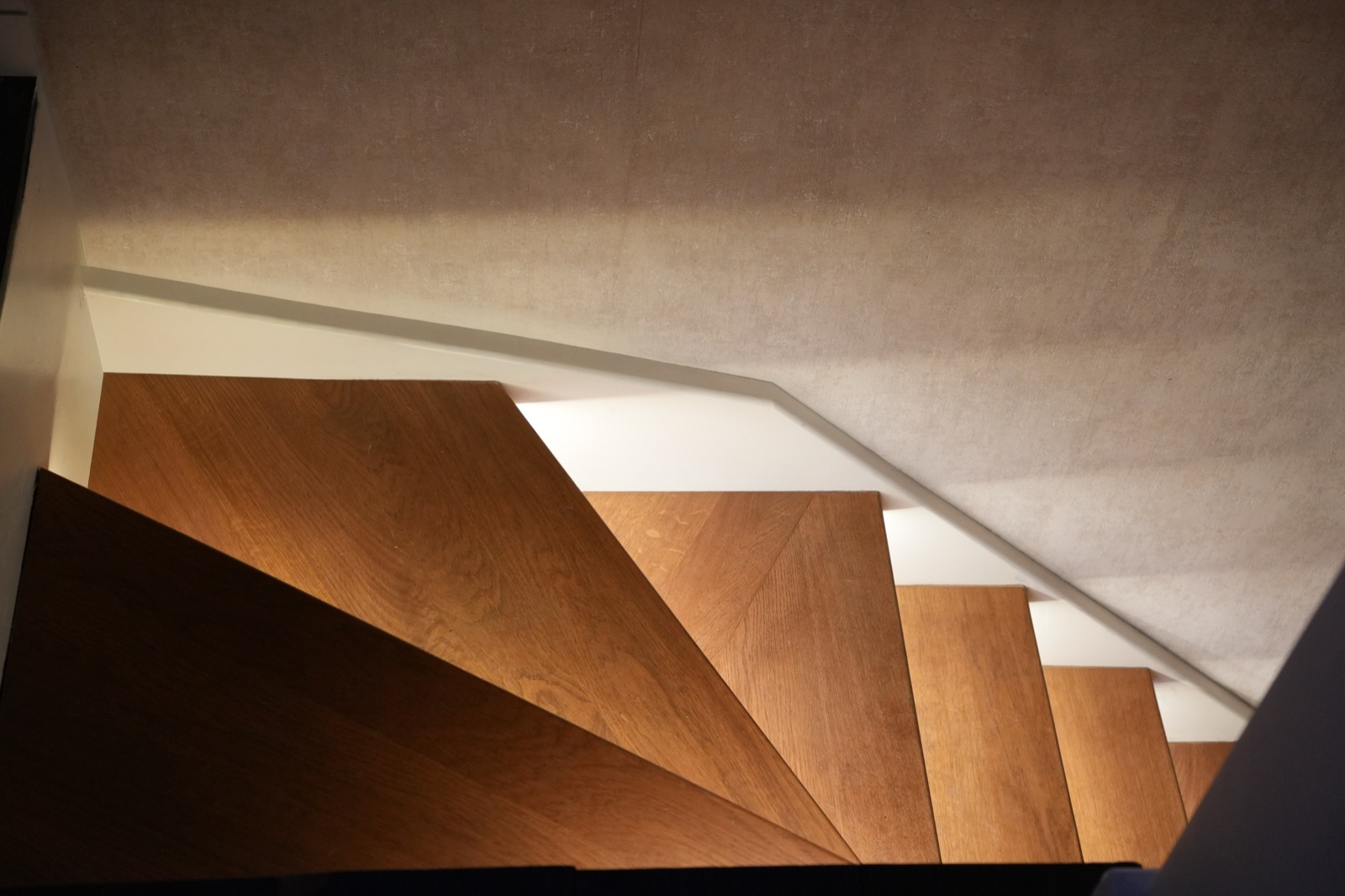 Wooden staircase viewed from below showing precision joinery